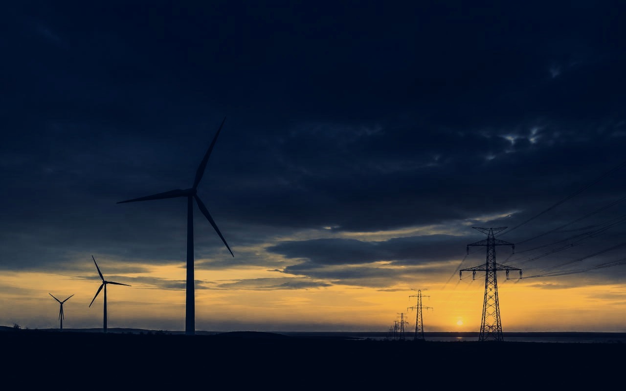 Wind turbines and transmission lines at sunset